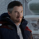 Dr. Strange, wearing a hoodie under his anorak, winks slyly.